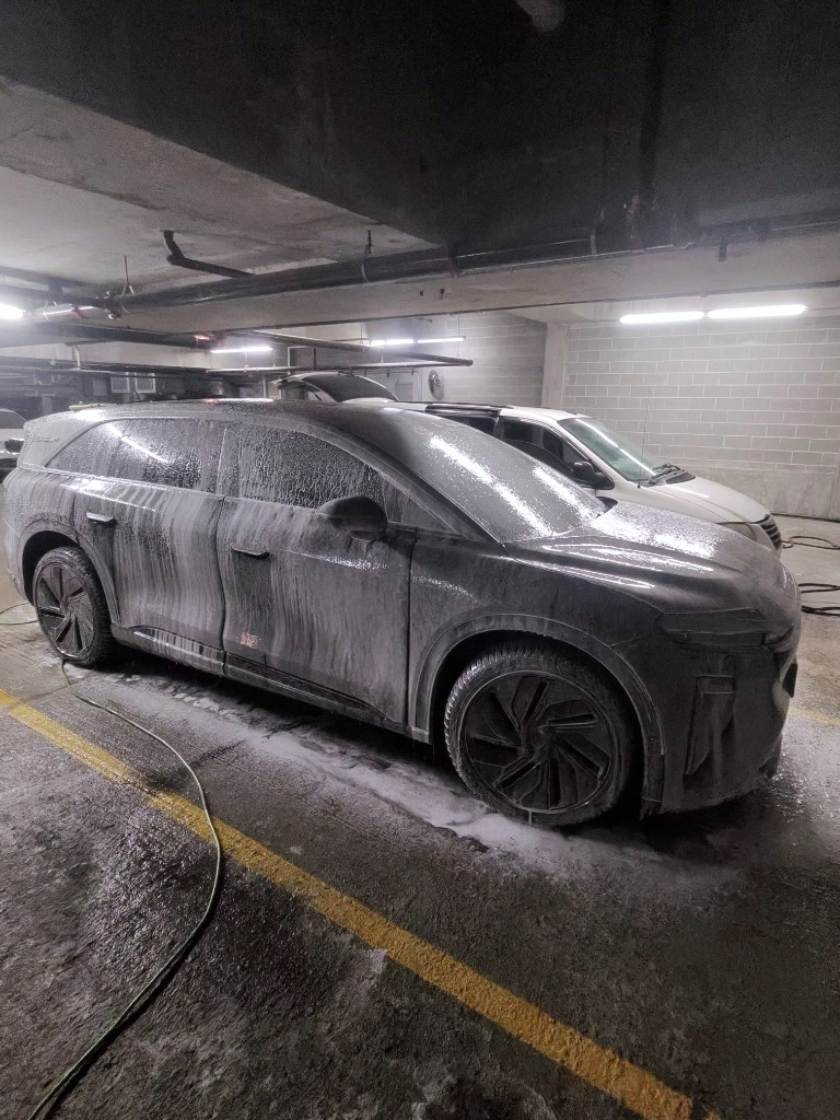 Mobile car wash foam pre-treatment on luxury SUV in Chicago parking garage